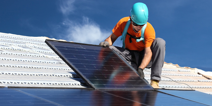 Ein Arbeiter verbaut Solarmodul auf einem Dach. (Foto: © Federico Rostagno/Fotolia.com)