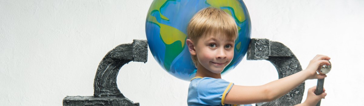 Ein kleiner Junge hält einen Globus in der Schraubzwinge (Foto: © Denis Aglichev/Fotolia.com)